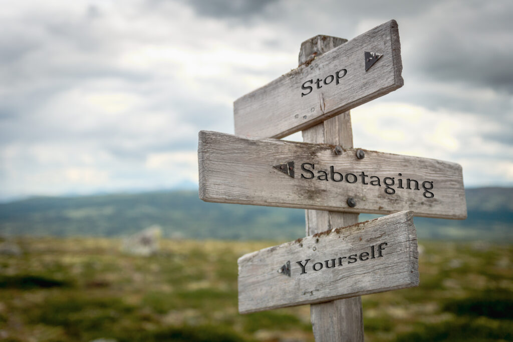 Wooden sign reading "Stop Sabotaging Yourself